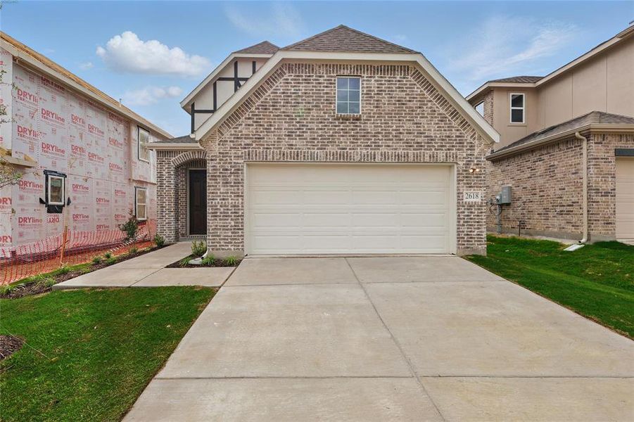 View of front of house featuring brick siding, driveway, a shingled roof, and a front lawn View of front of house featuring brick siding, driveway, a shingled roof, and a front lawn