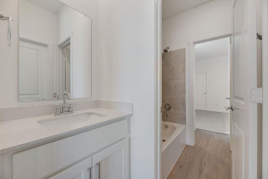 Full bath with vanity, wood finished floors, and bathtub / shower combination