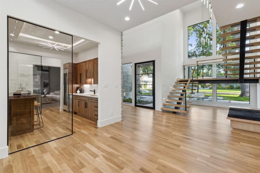 As you step into the entry, you'll be captivated by the bright open spaces and the bold architectural features of the home. Like the glass enclosed bar area and the floating stair.