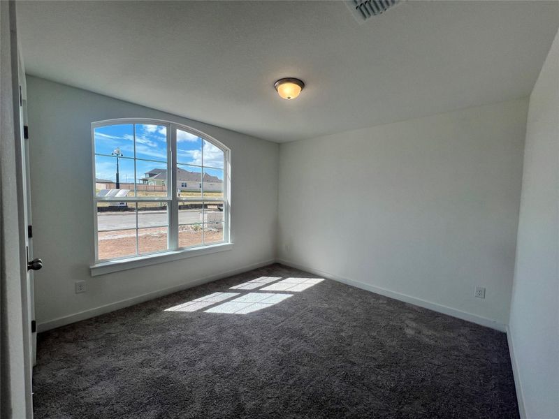 Empty room featuring dark colored carpet and baseboards Empty room featuring dark colored carpet and baseboards