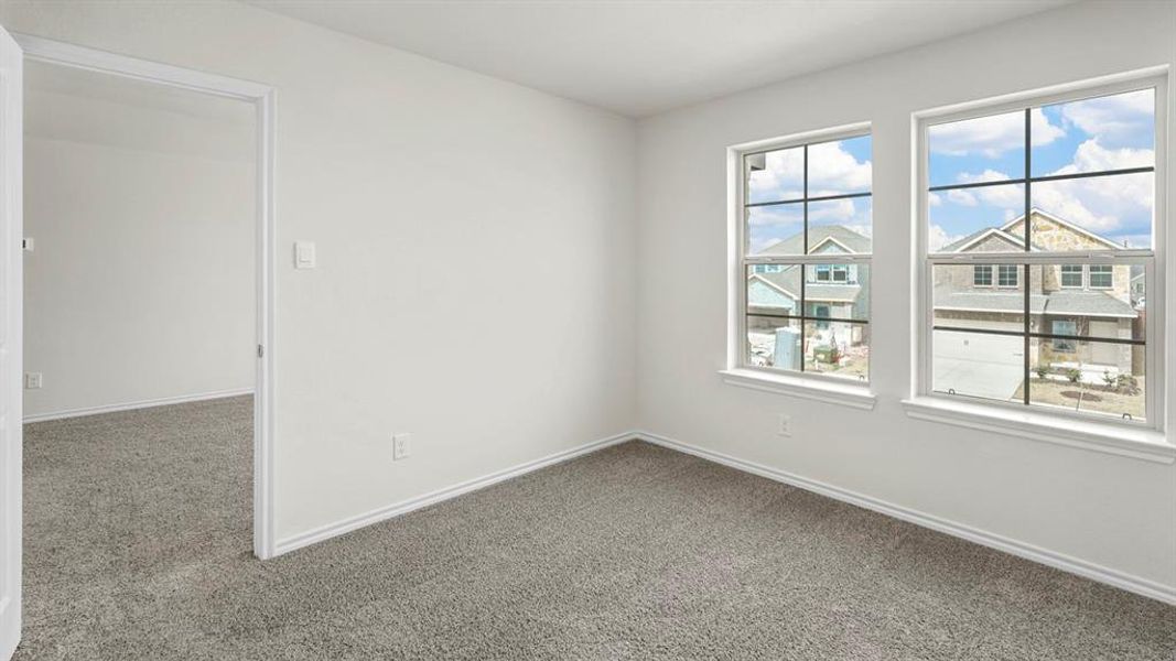 Room with gray carpeting, white walls, and two large windows featuring grid patterns
