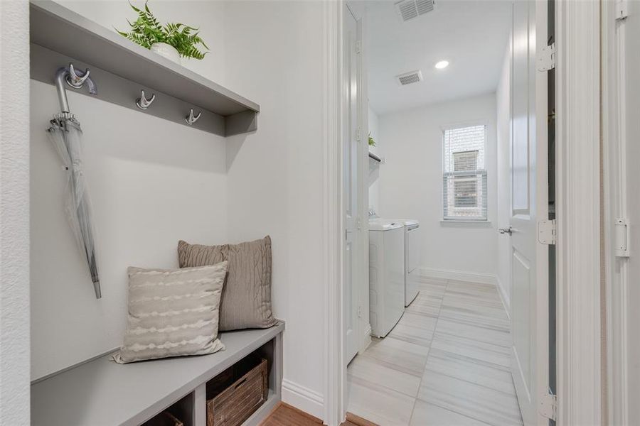 Mudroom featuring light tile patterned flooring and separate washer and dryer