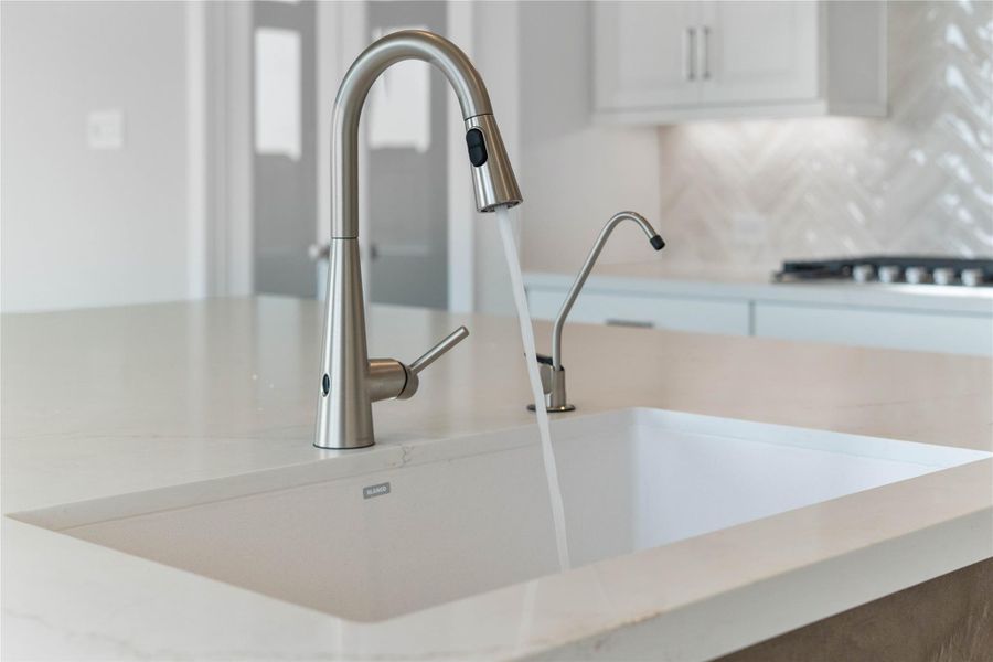 Moen Sleek - Stainless Steel pull-down faucet offers versatility and contemporary design, complemented by a convenient separate filtered water dispenser faucet.