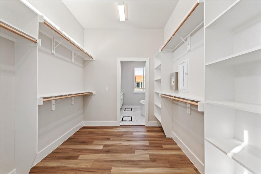 This expansive walk-in closet is built for real use, with custom shelving and full-length hanging rods on both sides, creating a dedicated dressing space that leads directly into the ensuite bath. Everything has a place, and nothing feels like an afterthought.