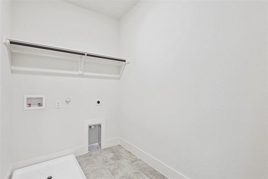 Clothes washing area featuring hookup for a gas dryer, light tile patterned flooring, hookup for a washing machine, and hookup for an electric dryer