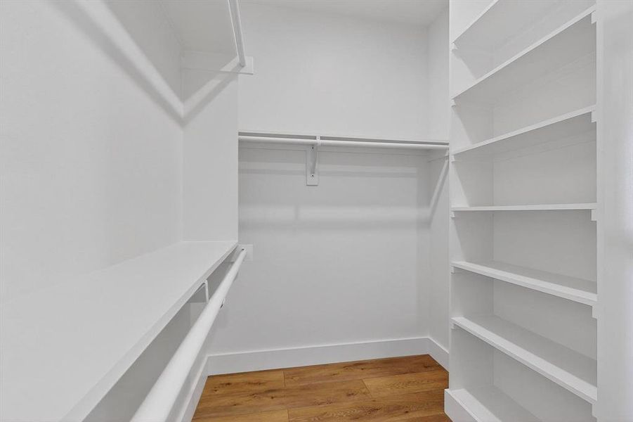 Spacious closet with light wood finished floors