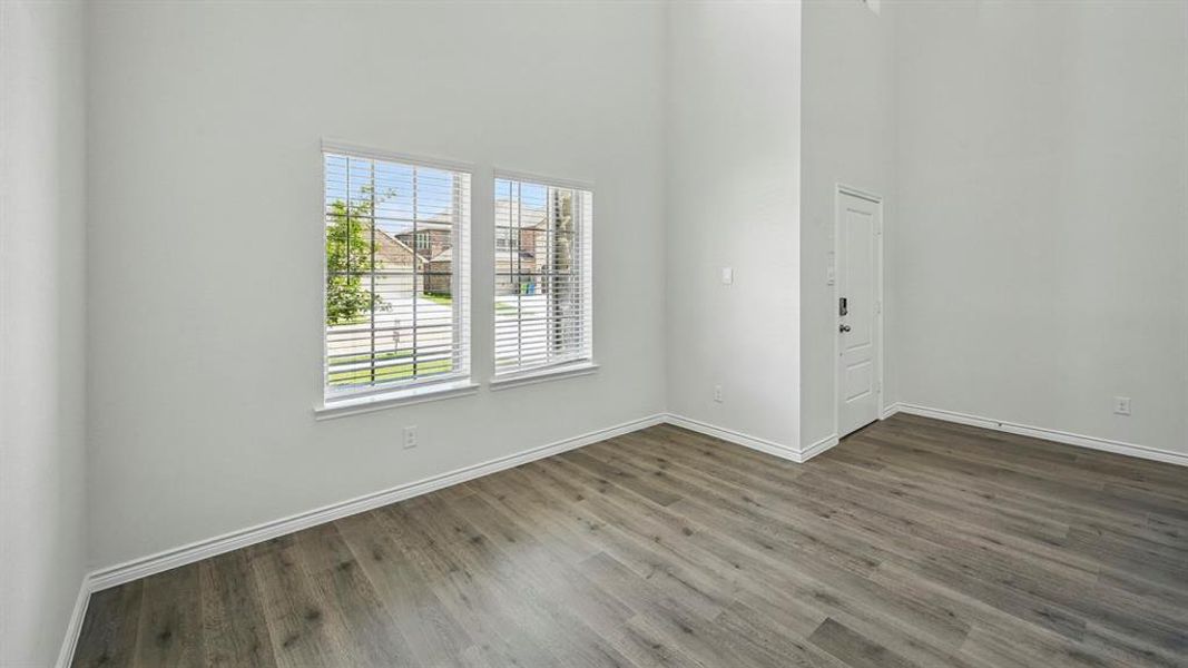 Spare room featuring a high ceiling and dark wood-style floors Spare room featuring a high ceiling and dark wood-style floors