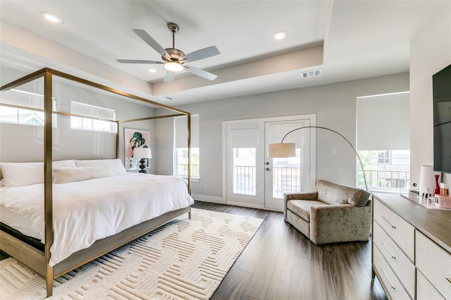 Bedroom with access to outside, multiple windows, ceiling fan, and hardwood / wood-style floors