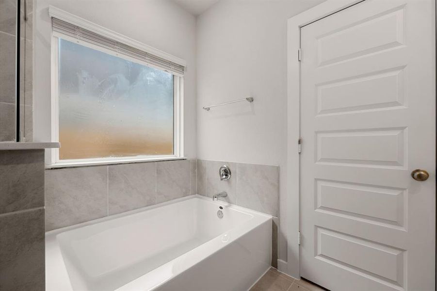 This additional view of the primary bath showcases the separate garden tub perfect for soaking after a long day.