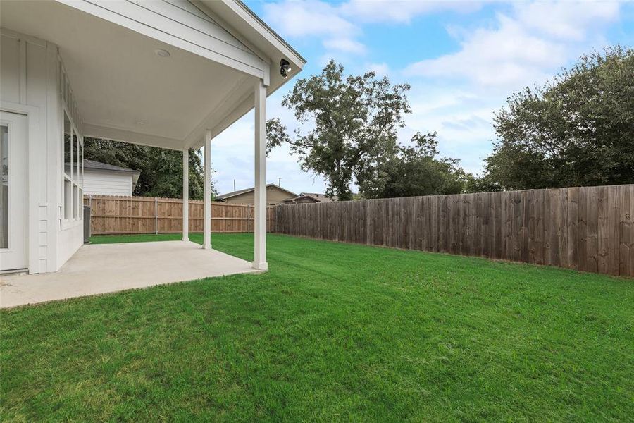 Fenced backyard with a patio area Fenced backyard with a patio area
