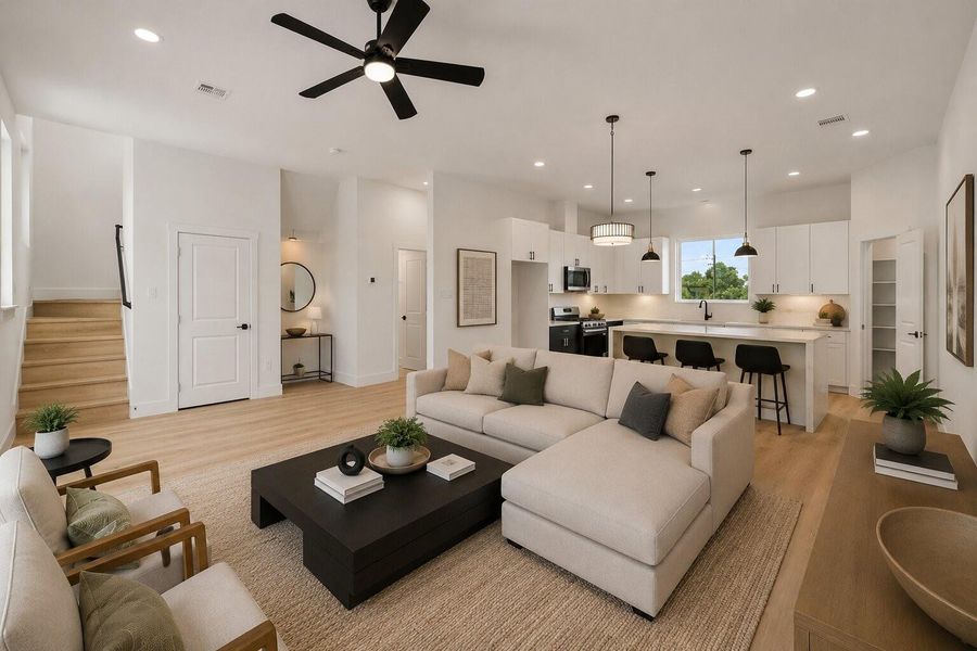 Sunlit open living space anchored by a chef-inspired kitchen with oversized island and designer lighting