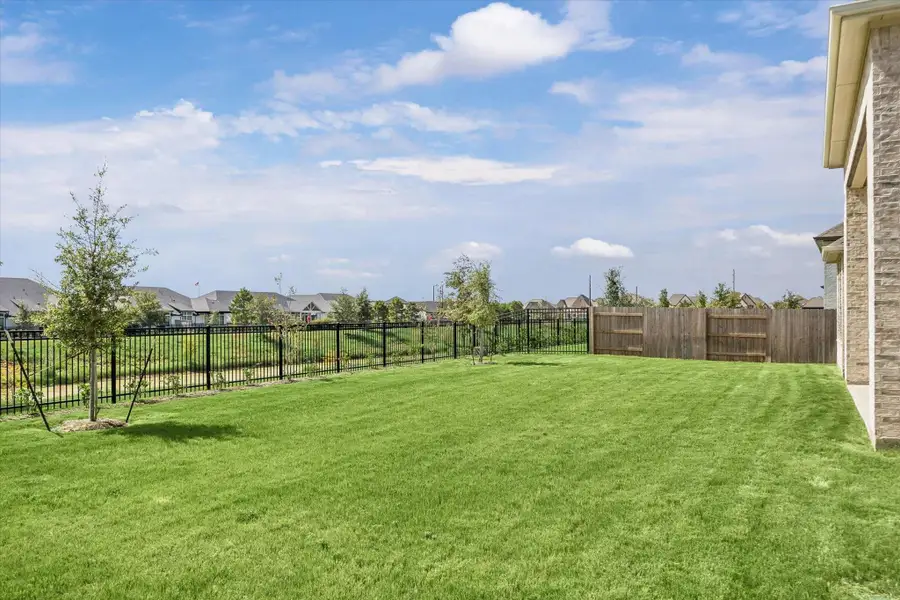 SPACIOUS BACKYARD FEATURES A LARGE GRASSY LAWN WITH OPEN GREENBELT VIEWS BEYOND THE IRON FENCE. SPACIOUS BACKYARD FEATURES A LARGE GRASSY LAWN WITH OPEN GREENBELT VIEWS BEYOND THE IRON FENCE.