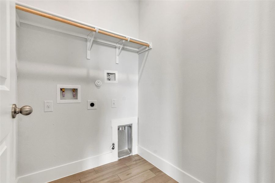 A dedicated laundry space provides essential hookups and a convenient hanging rod.