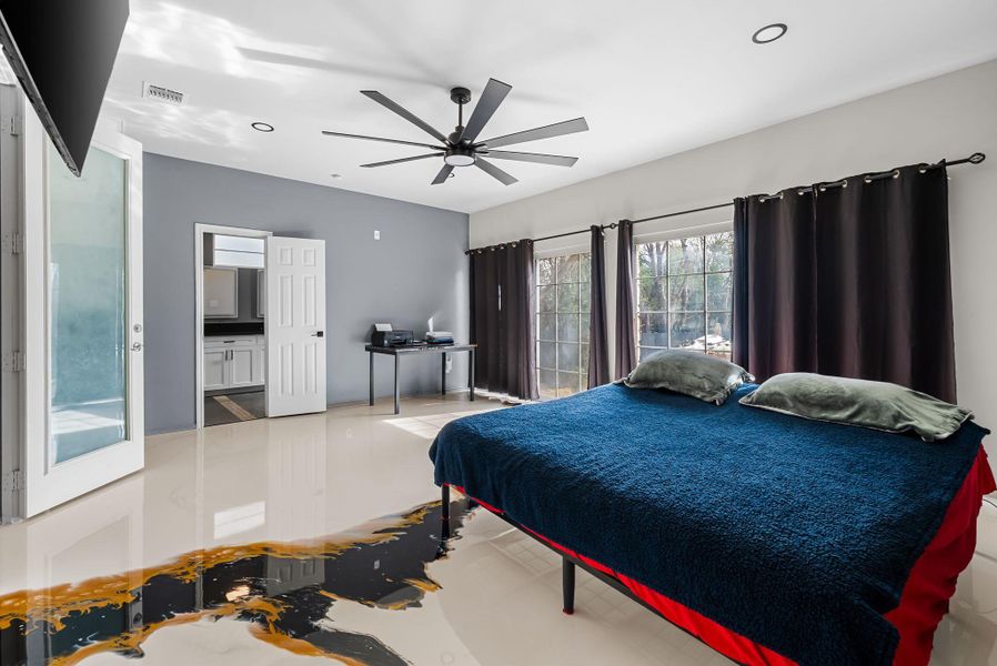 Bedroom with a ceiling fan, connected bathroom, and recessed lighting