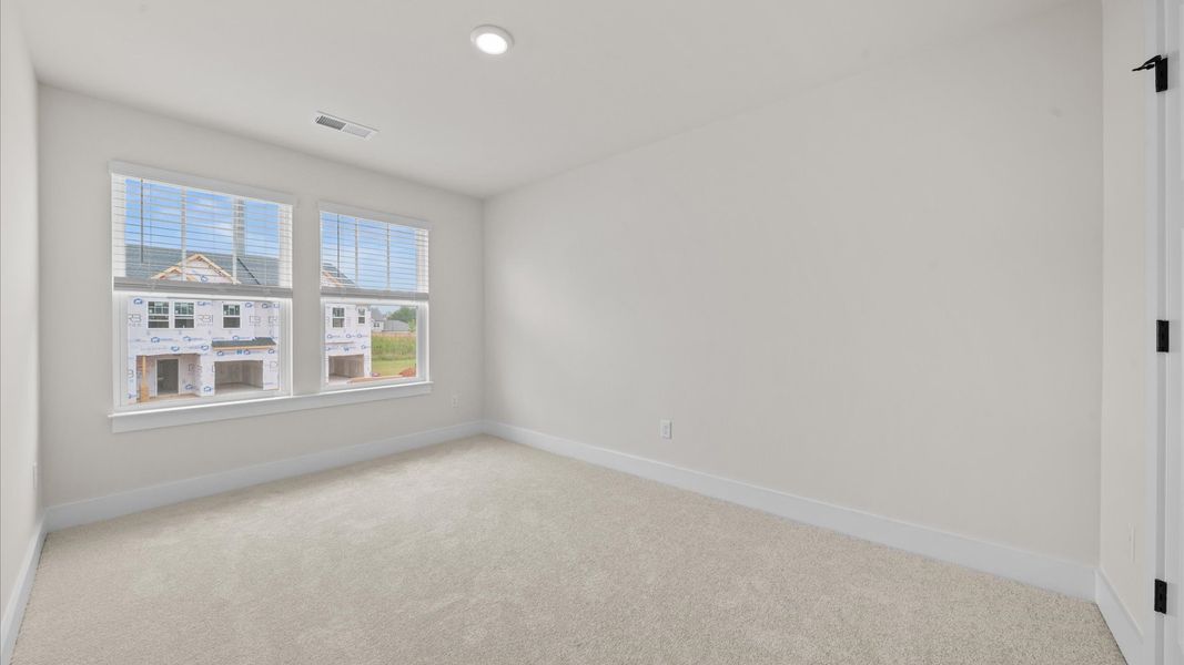 Tasteful bedroom with plush carpet, a walk-in closet, and large windows for abundant natural light Tasteful bedroom with plush carpet, a walk-in closet, and large windows for abundant natural light