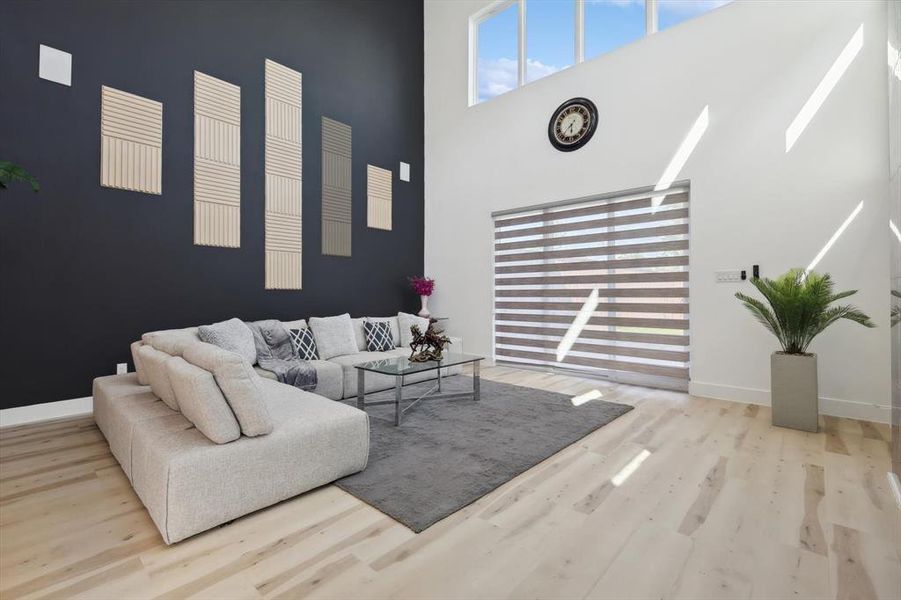 Living room with hardwood / wood-style floors and a high ceiling