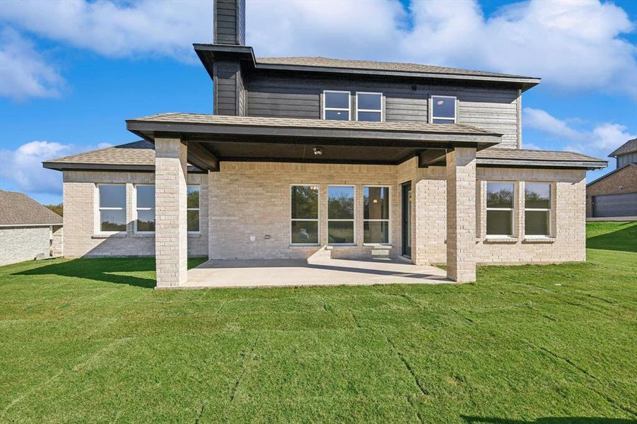 Rear view of property with a patio area and a yard