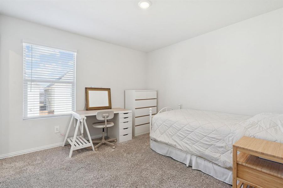 Bedroom featuring carpet and baseboards