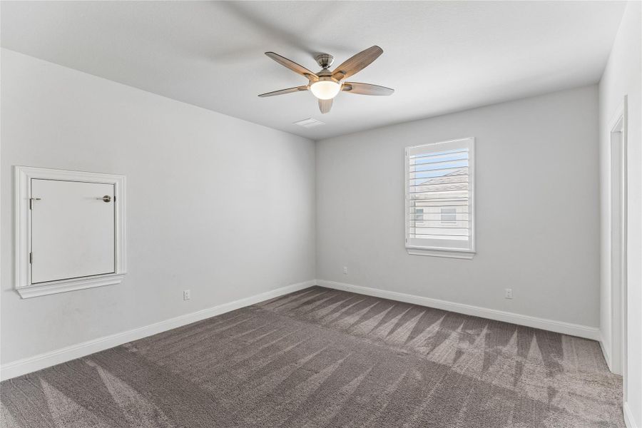 Comfortable carpeted bedroom featuring a modern ceiling fan for optimal airflow.