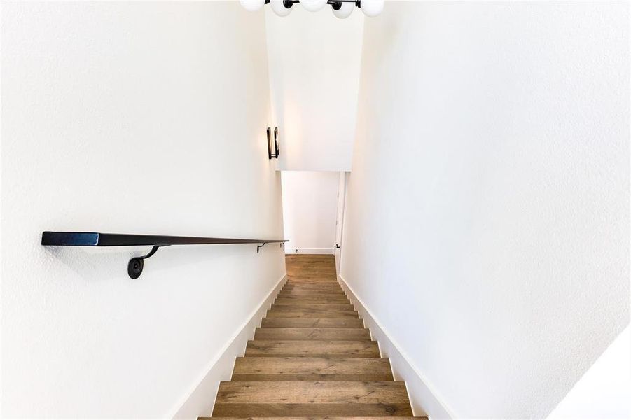 Staircase featuring hardwood / wood-style flooring