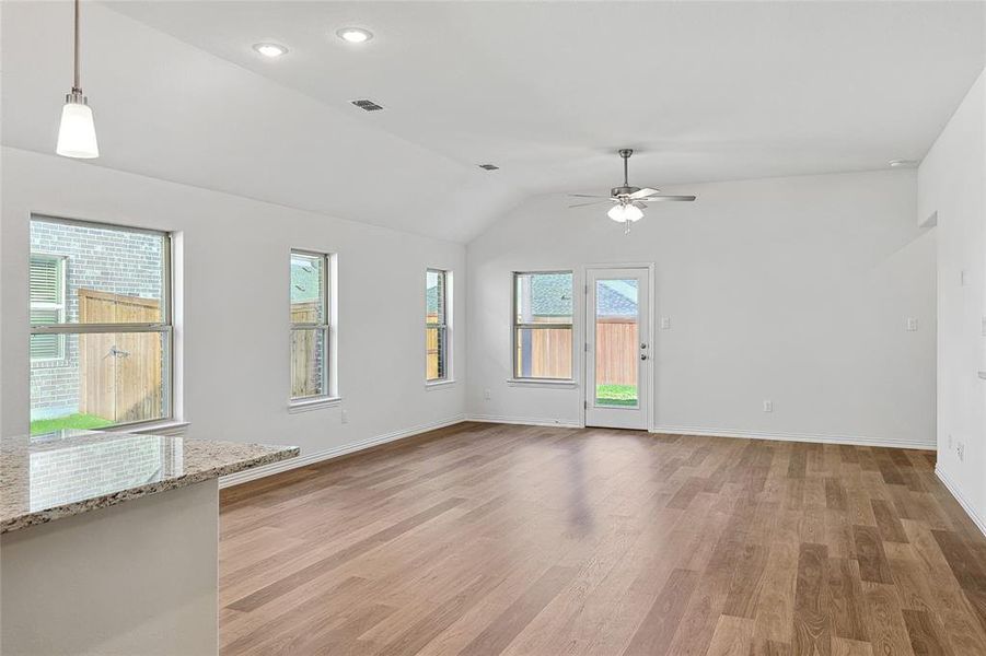 Unfurnished room featuring wood-type flooring, vaulted ceiling, and ceiling fan