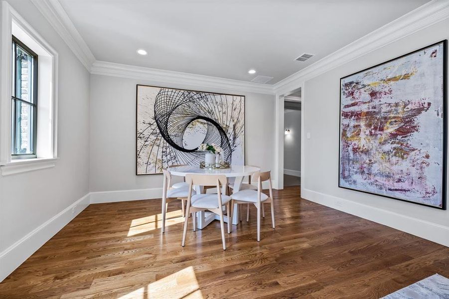 Dining space featuring visible vents, wood finished floors, baseboards, ornamental molding, and recessed lighting Dining space featuring visible vents, wood finished floors, baseboards, ornamental molding, and recessed lighting