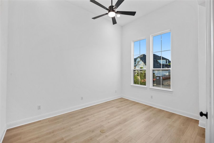 Spare room with light wood finished floors and a ceiling fan