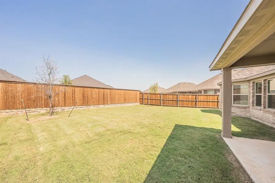 Fenced backyard with a patio area Fenced backyard with a patio area