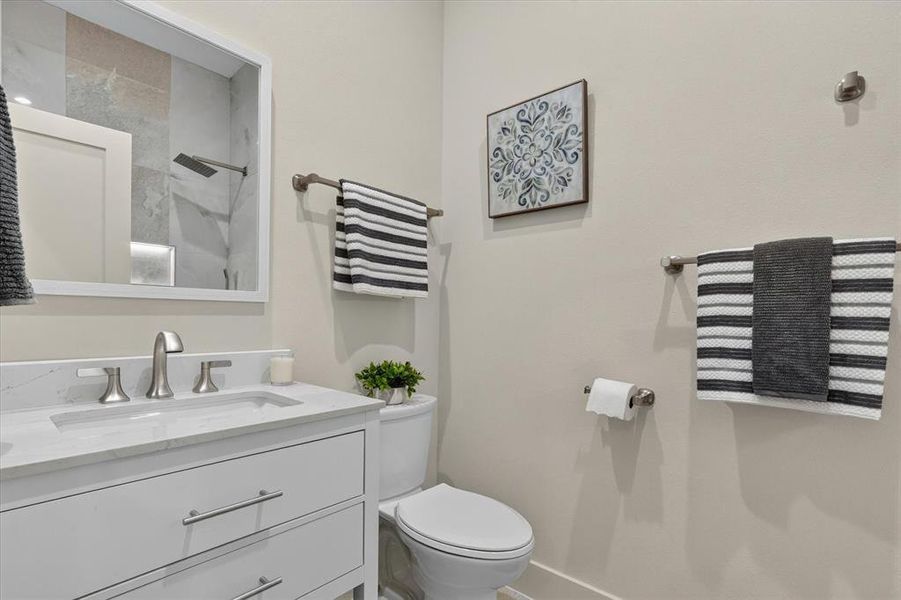 White vanity with an integrated sink, brushed nickel faucet, and contemporary hardware