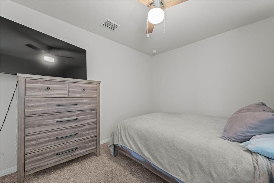 A cozy bedroom with a ceiling fan overhead, offering comfort and simplicity.