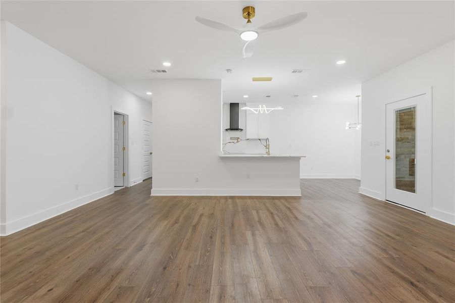 Open-concept living area featuring wood-finish flooring, recessed lighting, and a modern ceiling fan