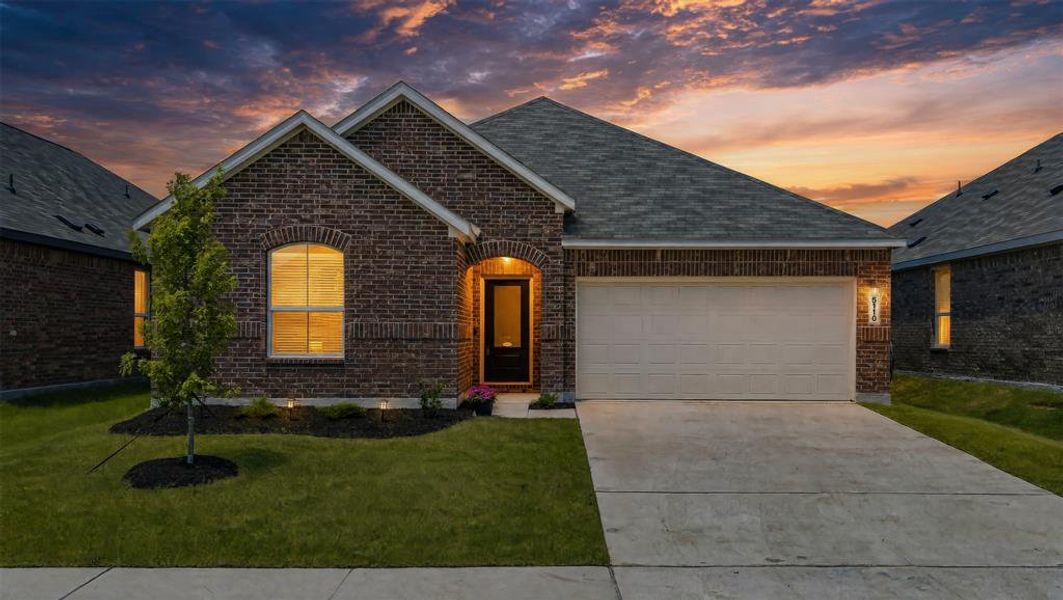 Brick exterior featuring a gabled roofline, arched entry, and an integrated garage Brick exterior featuring a gabled roofline, arched entry, and an integrated garage