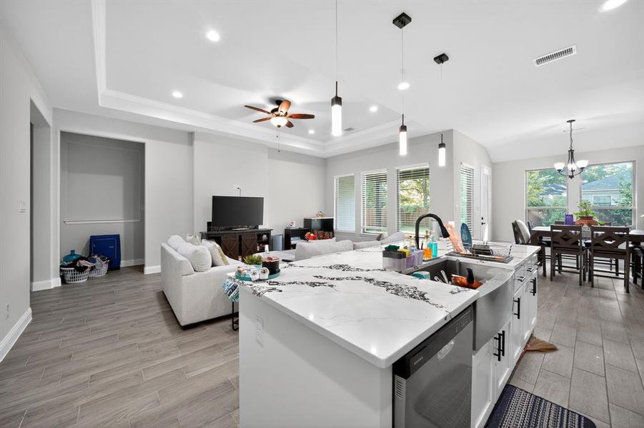 Kitchen featuring white cabinetry, decorative light fixtures, recessed lighting, light wood finished floors, and stainless steel dishwasher