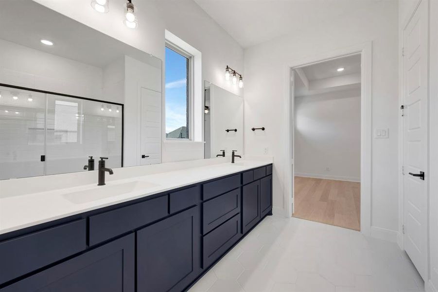 Bathroom featuring double vanity, light tile patterned flooring, a stall shower, and recessed lighting