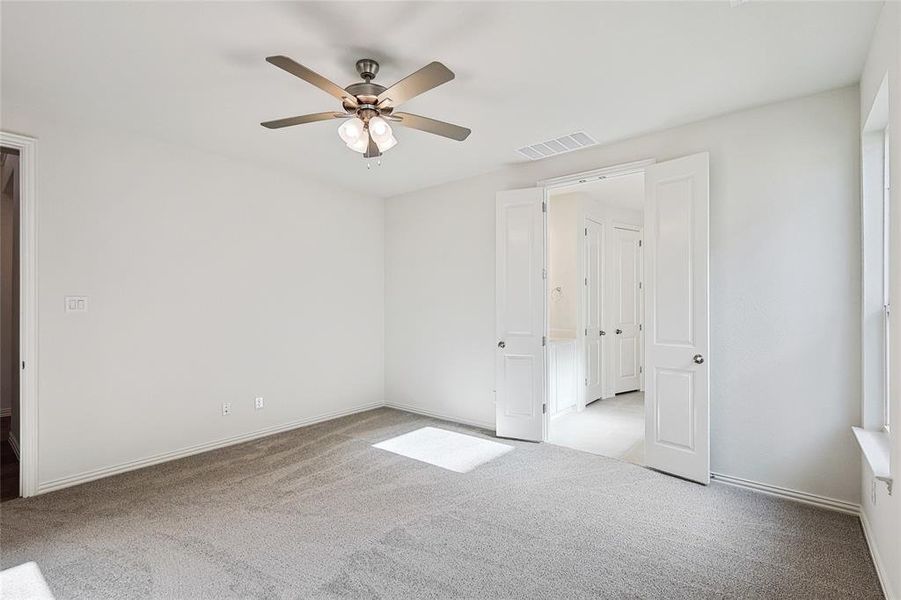 Carpeted empty room with ceiling fan