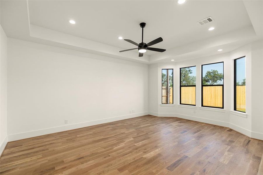 Your first floor primary suite looks to the back yard(very private with NO backyard neighbors), a tray ceiling as well as overhead recessed lighting, accentuate the white oak floors and tasteful wall color