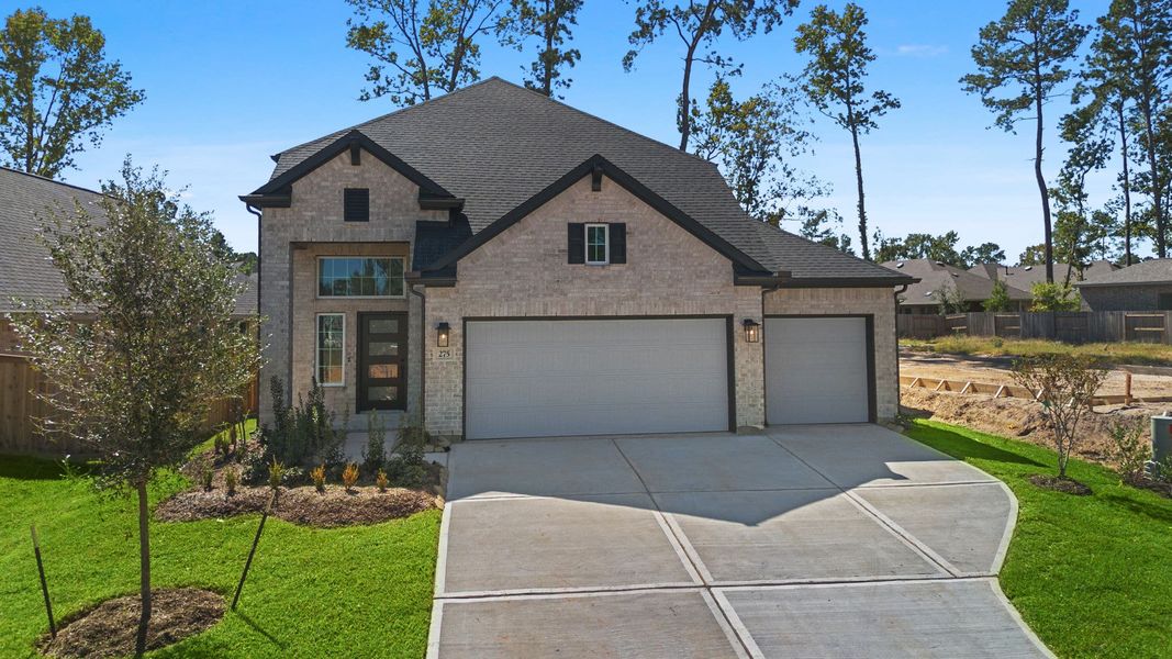 Front exterior of a new home in The Woodlands Hills, Willis, TX, highlighting curb appeal (Image 2). Front exterior of a new home in The Woodlands Hills, Willis, TX, highlighting curb appeal (Image 2).