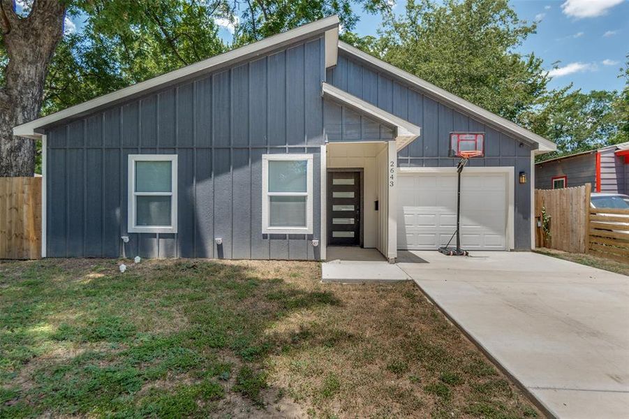 Modern gray board and batten exterior with white trim, a single-car garage, and a covered entry Modern gray board and batten exterior with white trim, a single-car garage, and a covered entry
