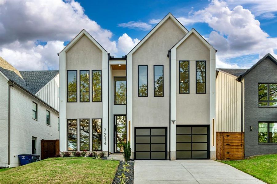 View of front facade featuring a front yard and a garage