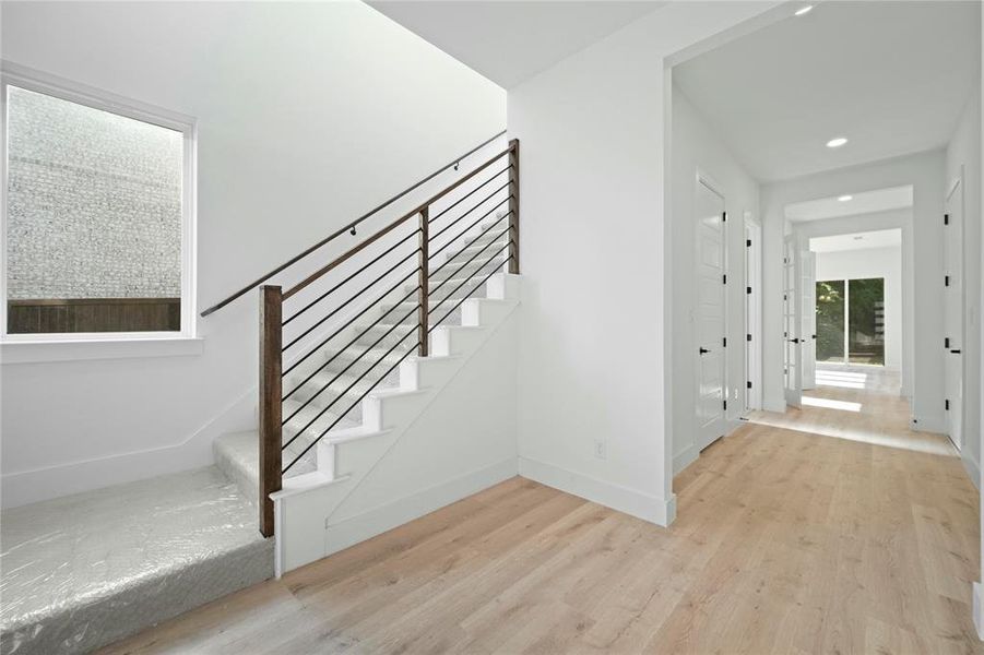 Staircase featuring wood finished floors and recessed lighting