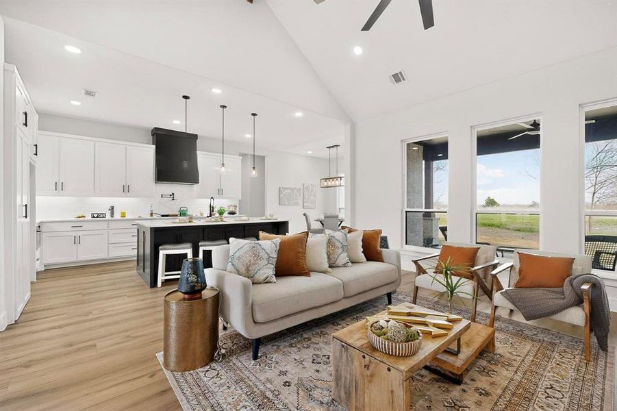 Living area with light wood-style flooring, lofted ceiling, recessed lighting, and a ceiling fan