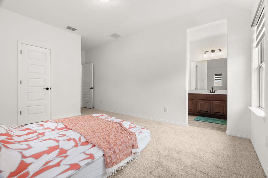 A well-lit bedroom offering a seamless transition to a private ensuite bathroom. A well-lit bedroom offering a seamless transition to a private ensuite bathroom.
