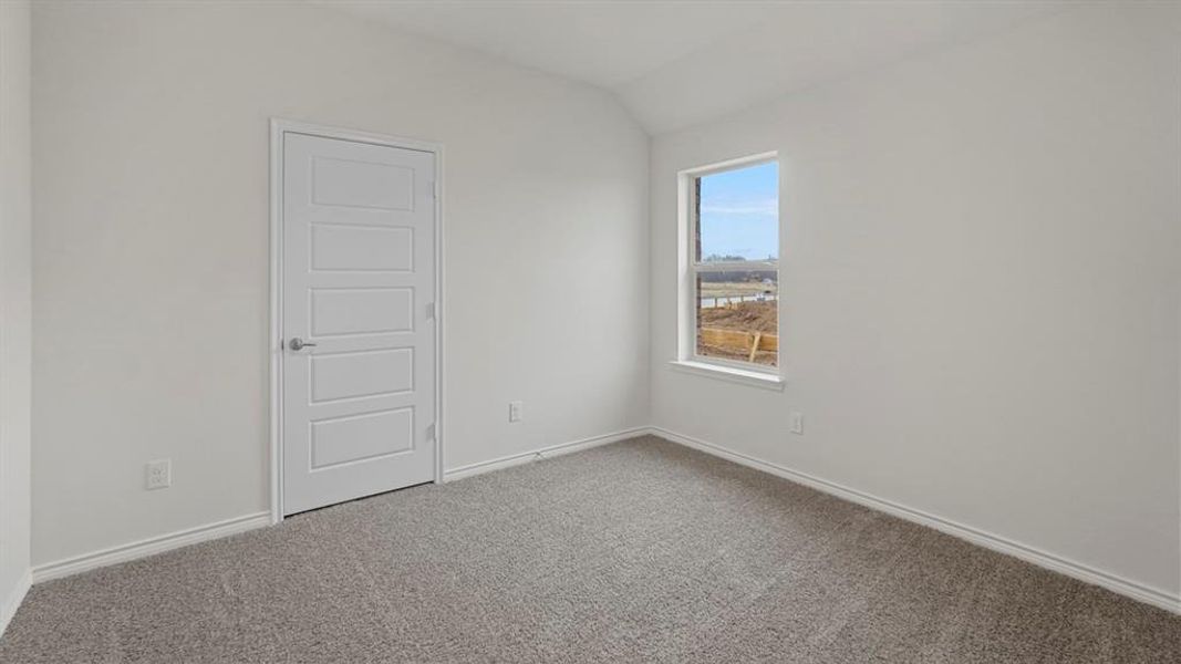 Neutral paint palette, textured carpet flooring, white trim, modern paneled door, and a single window