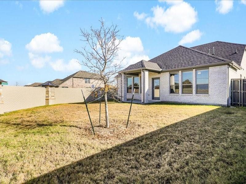 Rear view of property with a lawn