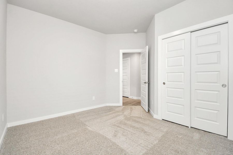Secondary bedrooms showcase 5-panel doors adorned with modern hardware, large windows , and spacious closets featuring sleek and contemporary finishes.