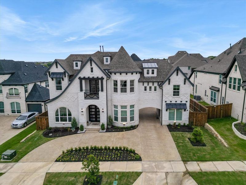 White brick exterior featuring a prominent turret, dark gabled rooflines, and a covered entryway White brick exterior featuring a prominent turret, dark gabled rooflines, and a covered entryway