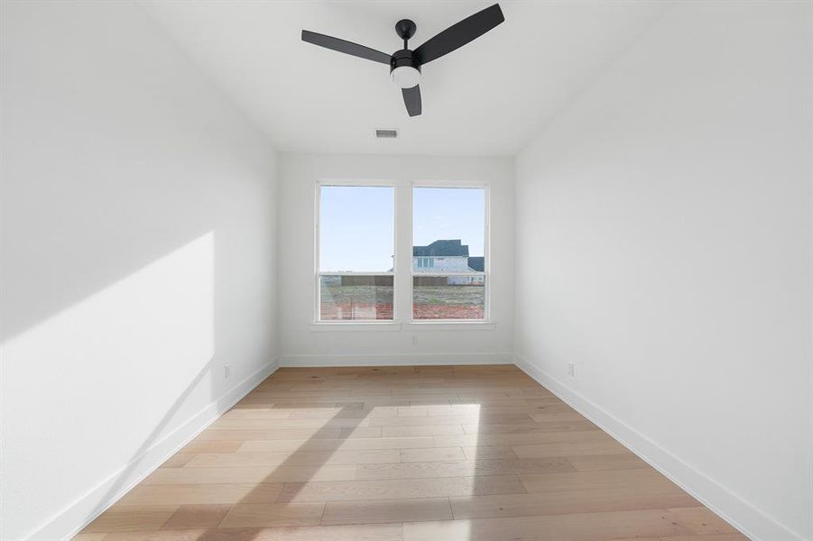Empty room with light wood-type flooring and a ceiling fan