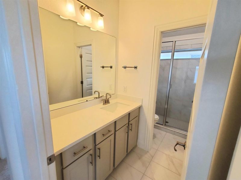 Full bathroom featuring toilet, vanity, and a stall shower Full bathroom featuring toilet, vanity, and a stall shower