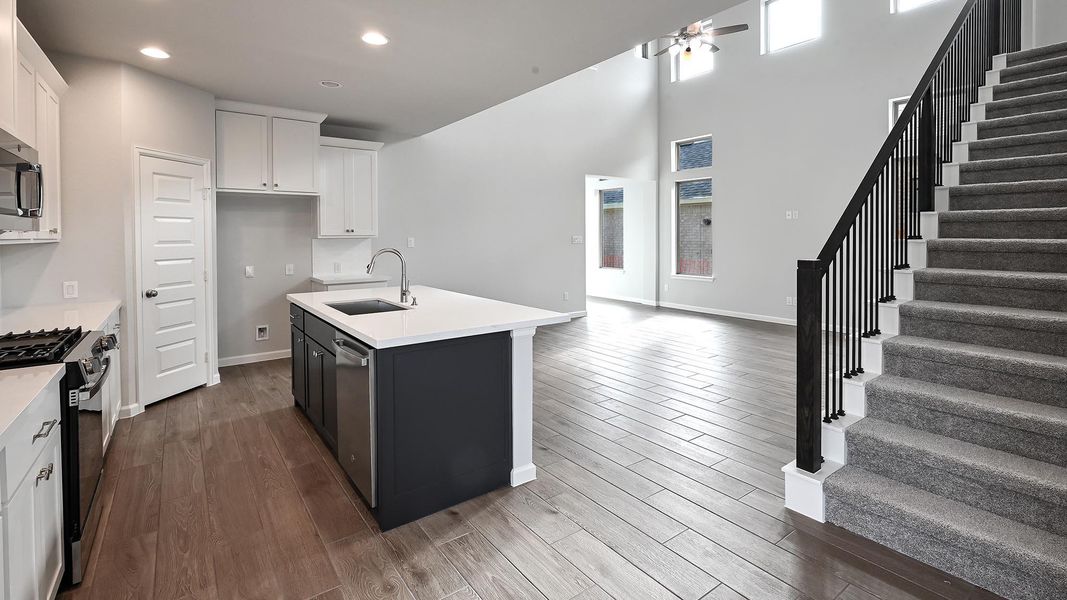 Kitchen featuring white cabinets, appliances with stainless steel finishes, a kitchen island with sink, dark wood finished floors, and recessed lighting Kitchen featuring white cabinets, appliances with stainless steel finishes, a kitchen island with sink, dark wood finished floors, and recessed lighting