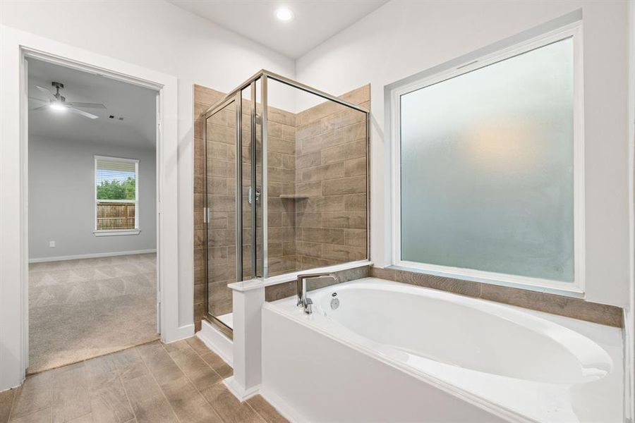 The primary en-suite has a soaking tub to give you that spa experience. The large privacy window allow lots of nature light in the space. . Representation. Actual color and selections can vary.